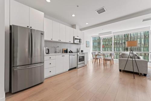 a kitchen with white cabinets and a stainless steel refrigerator at Stylist Downtown LA Gateway- Studio Apt in Los Angeles