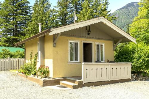 a small yellow house with a garage at Richca Chalets Resort in Hope