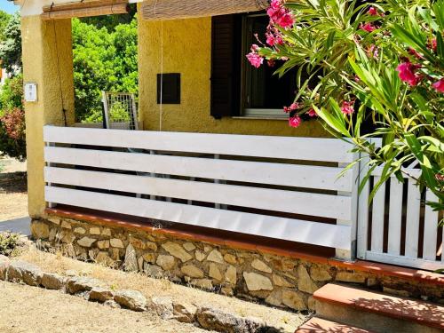 a white fence in front of a house with flowers at Tramonto, Rena Majore in Rena Majore