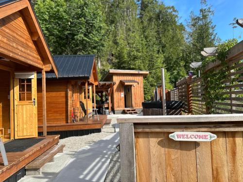 a group of wooden lodges with a sign on a fence at Garden Bay Hideaway - Glamping & RV in Garden Bay