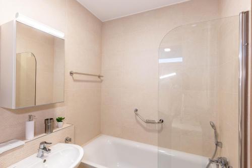 a bathroom with a white tub and a sink at Sunset Resort 113 in Fonyód
