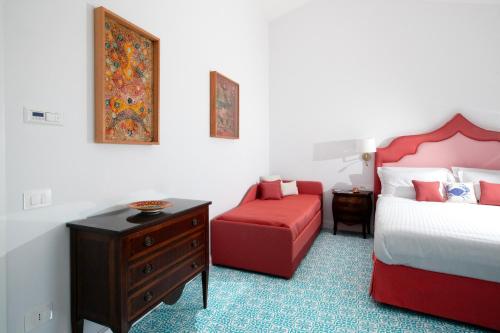 a bedroom with a bed and a red chair at De Pando Panoramic Suites 1096 in Scala