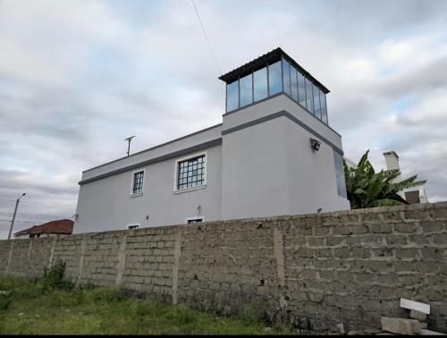 a white lighthouse on top of a brick wall at Zanzi Layover JKIA and SGR in Jomo Kenyatta Airport Nairobi