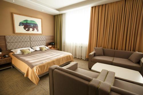 a hotel room with a bed and a couch at GREEN Which Hotel in Petropavlovsk