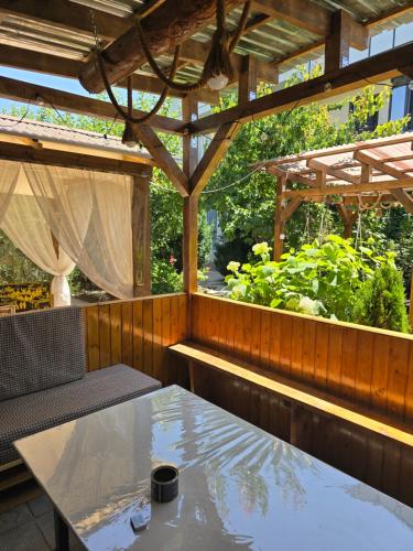 a patio with a table and a wooden pergola at Olga Guest House in Cholpon-Ata
