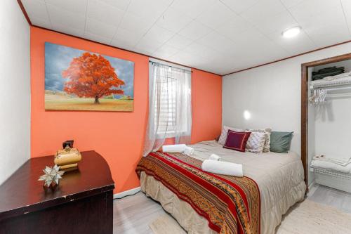 ロングモントにあるSpacious and Comfy Close to Everything Backyardのオレンジ色の壁のベッドルーム(ベッド1台、デスク付)