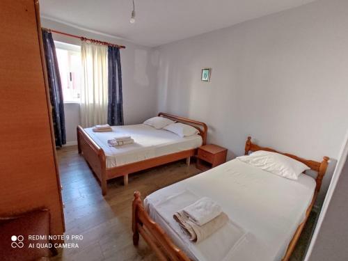 a bedroom with two beds and a mirror at Spacious-Central Apartment in Himare