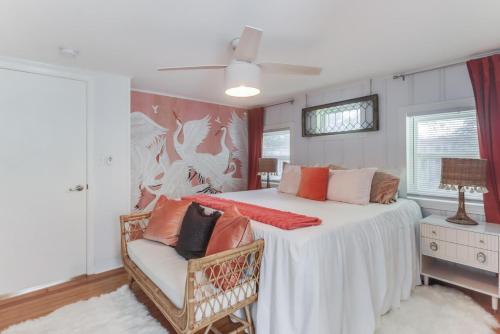 Un dormitorio con una gran cama blanca con una silla. en The Cabana on the Coast, en Gulfport