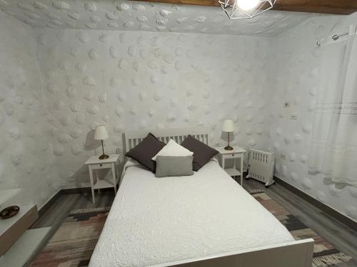 a bedroom with a white bed with two tables at Casa Rural Juli in Santa Cruz de Tenerife