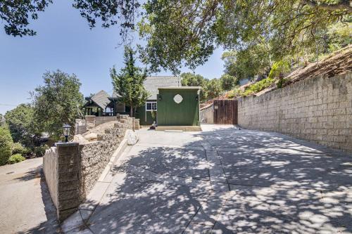 a house with a green dumpster next to a brick wall at The Storybook Cottage Every Stay Tells a Story! in Conejo Valley Trailer Park