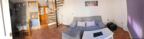 a living room with a couch and a staircase at El rincon de la mesta in Arroyo Frio