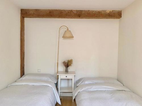two beds in a room with a lamp and a table at A lived-in apartment with soul in Santander
