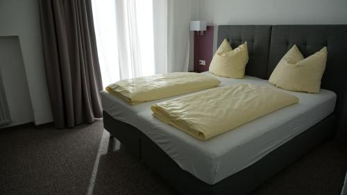 a bed with two pillows on it in a room at Hotel Sonnenbichl in Halblech