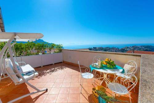 a balcony with a table and chairs and the ocean at De Pando Panoramic Suites 1096 in Scala