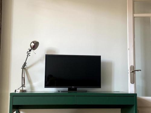 a flat screen tv sitting on top of a green table at A lived-in apartment with soul in Santander