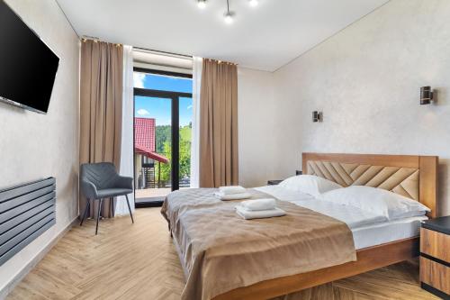 a bedroom with a large bed and a television at Smerichka in Bukovel