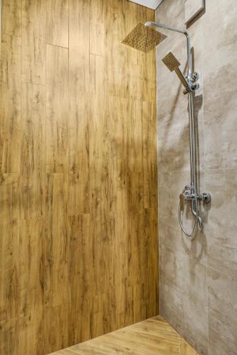 a shower in a bathroom with a wooden wall at Smerichka in Bukovel