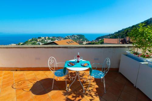 a table and chairs on a balcony with a view of the ocean at De Pando Panoramic Suites 1096 in Scala