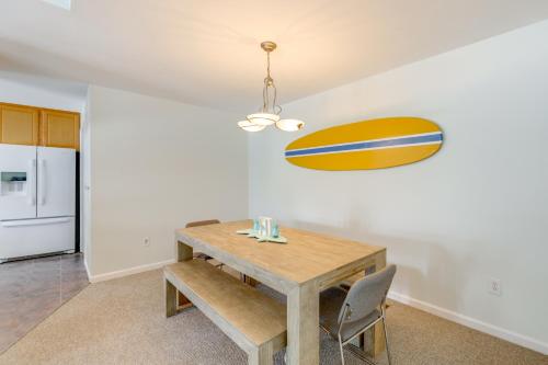 a dining room with a table and a surfboard on the wall at 2 Mi to Bethany Beach Home with Furnished Deck in Ocean View