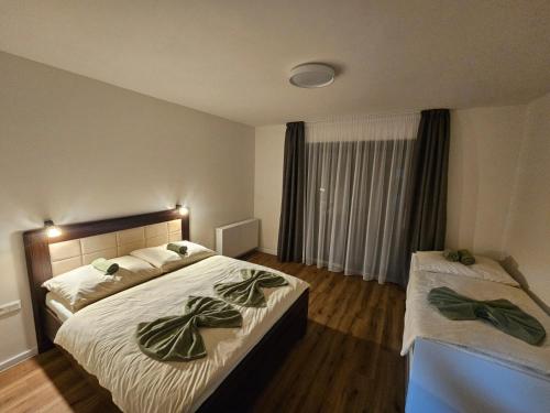 a bedroom with two beds with green towels on them at Levander 2 in Králiky