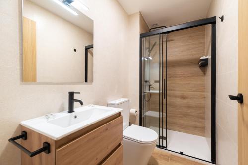 a bathroom with a sink and a shower at Suites Deluxe By Roque in Vigo