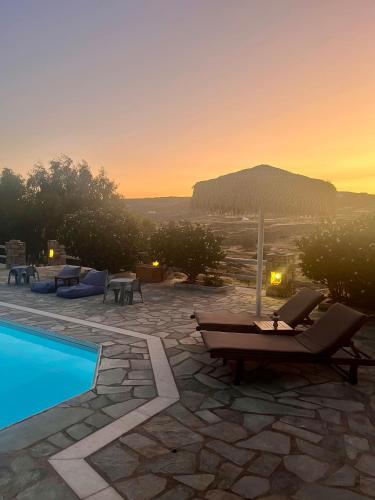 a resort with a swimming pool and a sunset at Casa Paros in Parikia