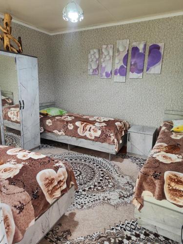 a room with two beds and a mirror and a room with at Olga Guest House in Cholpon-Ata