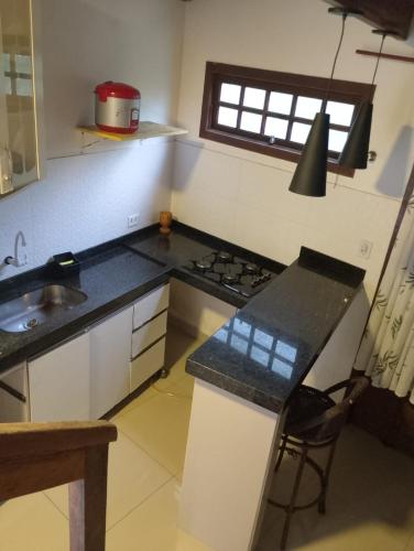 a kitchen with a sink and a stove top oven at Refúgio do Kairós in Ubatuba