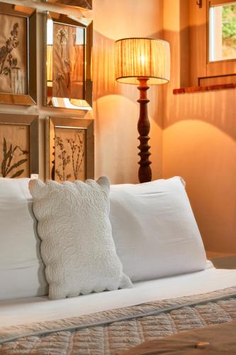a bed with a white pillow and a lamp at Relais Sant'Elena in Bibbona
