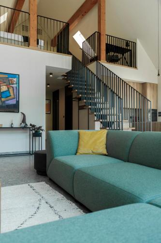 a living room with a blue couch and stairs at Villa Natura in Plešivica