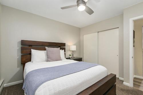 a bedroom with a large bed with a ceiling fan at Breathtaking Condo in the Heart of Old Town in Fort Collins