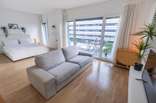 a living room with a couch and a large window at Lisbon East Residence in Lisbon