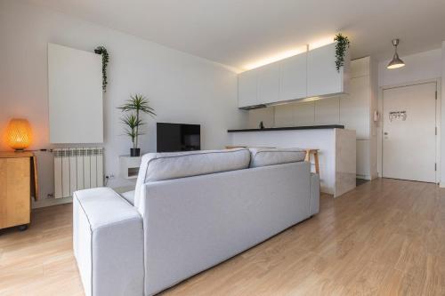 a living room with a white couch and a kitchen at Lisbon East Residence in Lisbon