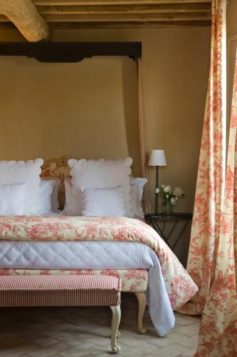 a bedroom with a large bed with white pillows at Relais Sant'Elena in Bibbona