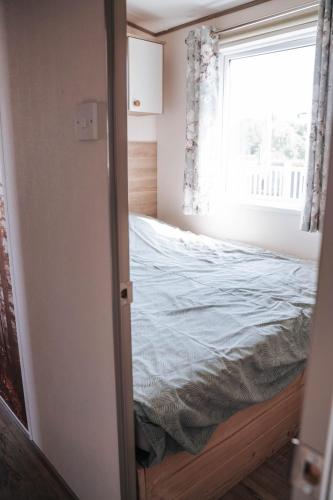 a small bedroom with a bed and a window at vakantiewoning aan het water in Merksplas