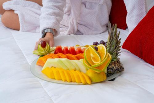 a plate of fruit and vegetables on a bed at Hotel Palace 1 in Florianópolis