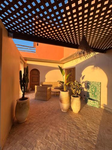 a living room with potted plants and a wooden ceiling at Villa Sakina Essaouira in Ounagha