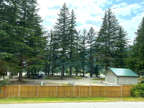 a wooden fence in front of a yard with trees at Richca Chalets Resort in Hope