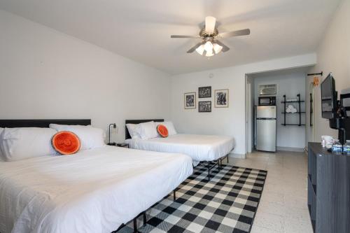 two beds in a room with a ceiling fan at Lumber Jill Lodge 16 Two Queen Room in Balsam Lake