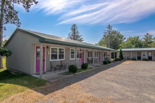 a building with pink doors and a yard at Lumber Jill Lodge 17 King Bed Retreat in Balsam Lake