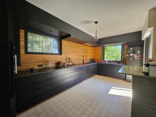 a large kitchen with black cabinets and a counter top at Belle villa avec piscine à Montpellier in Montpellier