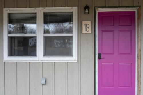 a pink door and a window on a house at Lumber Jill Lodge 18 Cozy King Room in Balsam Lake
