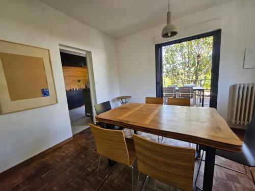 a dining room with a wooden table and chairs at Belle villa avec piscine à Montpellier in Montpellier