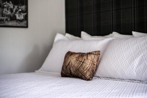 a pillow sitting on top of a bed with white pillows at Lumberjill Lodge 11 King Room in Balsam Lake