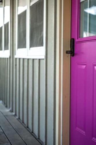 a pink door and windows on a building at Lumberjill Lodge 12 King Room in Balsam Lake