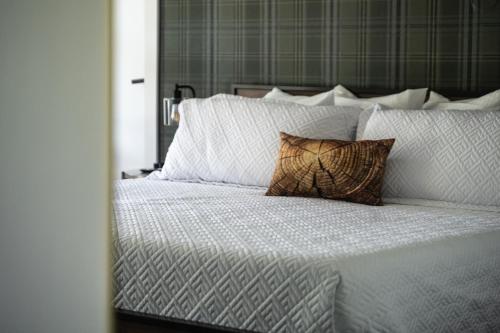 a large white bed with a pillow on it at Lumberjill Lodge 11 King Room in Balsam Lake