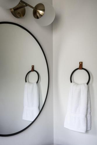 a mirror with white towels on a wall at Lumberjill Lodge 11 King Room in Balsam Lake