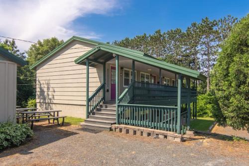 a small house with a porch and a bench at Lumberjill Lodge 12 King Room in Balsam Lake