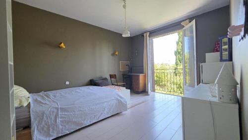 a bedroom with a bed and a large window at Belle villa avec piscine à Montpellier in Montpellier