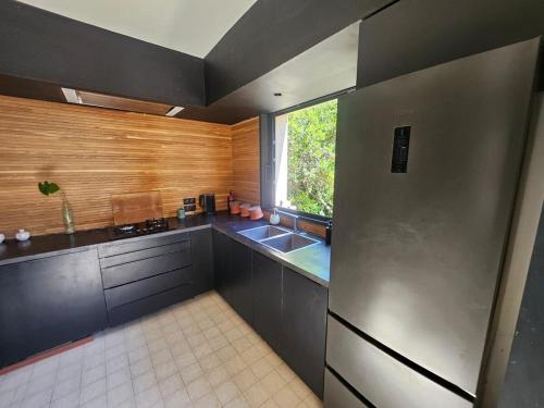 a kitchen with a stainless steel refrigerator and a window at Belle villa avec piscine à Montpellier in Montpellier